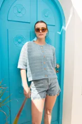 Saco tejido calado color ocre, con mangas al codo y botones de coco. Tiene grifa de cuero en la espalda.