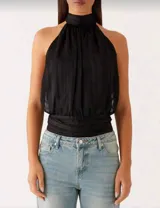 Blusa negra con cuello halter, espalda descubierta y lazo en la nuca.