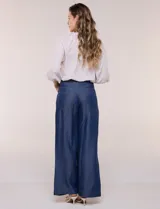 Pantalón wide leg de denim liviano gris, con tiro alto, presillas para cinturón, bolsillos laterales y corte recto de piernas anchas.
