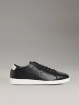 Zapatillas urbanas Calvin Klein de perfil bajo, color negro con suela blanca y detalle beige en el talón. Confeccionadas en cuero granulado, cuentan con cordones negros y el monograma de la marca grabado en el lateral.