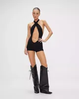 Mono negro ajustado al cuerpo, con escote halter cruzado y abertura en el abdomen.