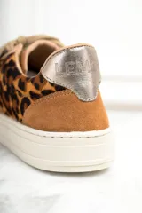 Zapatillas bajas de cuero con estampado animal print, detalles en cuero color marrón y puntera metalizada dorada.