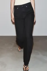 Jeans de tiro alto, pernera recta y larga, estilo clásico con cinco bolsillos, cierre frontal con cremallera y botón metálico.