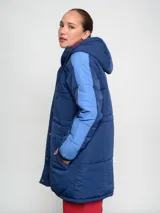 Parka larga de abrigo Umbro del Club Nacional de Football, color rojo con detalles en naranja en las mangas. Cuenta con capucha, cierre frontal con botones a presión y escudo del club bordado en el pecho.