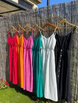 Vestido largo color naranja de breteles finos, con escote en V y botones frontales.