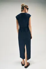 Vestido midi de denim azul oscuro, con escote en V, mangas cortas y detalles de entredoses en el escote y la cintura. Cuenta con cierre trasero con cremallera oculta.