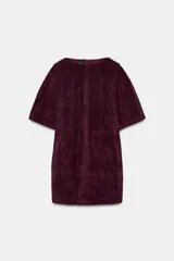 Vestido corto de ante con cuello redondo, manga corta y bolsillos delanteros. Presenta un diseño estructurado con forro interior y cierre de cremallera oculta en la espalda.
