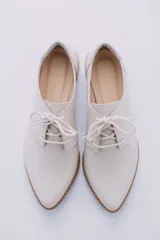 Zapato acordonado de cuero color beige con taco de madera de 3 cm.