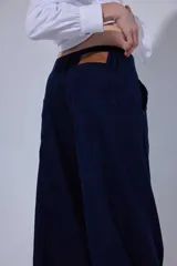 Pantalón de tiro medio y piernas anchas, confeccionado en mezcla de lino y algodón, con bolsillos delanteros y traseros con detalles de costuras pespunteadas a contratono.