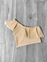 Top corto con un solo hombro y volado grande.