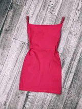 Vestido corto fucsia con breteles finos y corte ajustado.