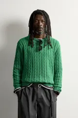 Sweater de punto verde con diseño de trenzas, cuello redondo y manga larga, de corte regular fit y acabados en rib.