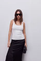 Musculosa de calce ajustado, confeccionada en tejido acanalado de color blanco, con escote redondo y breteles finos.