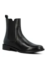 Bota tipo Chelsea de cuero negro, con paneles elásticos laterales y tirador en la parte trasera. Presenta un diseño de caña media con suela plana y taco bajo cuadrado.