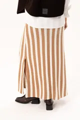 Falda larga tejida a rayas verticales color beige y blanco, con pretina elástica y tajos laterales.