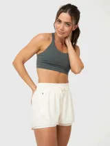 Top deportivo de alto impacto en color verde militar, con diseño de tirantes cruzados en la espalda y almohadillas removibles.