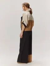 Chaquetas de lino bicolor en tonos blanco y beige, con diseño holgado, cuello alto, cierre frontal de botones, bolsillos con solapa en el pecho y mangas cortas con presilla y botón.