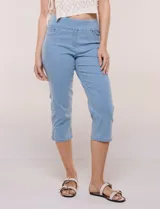 Pantalón capri en denim elastizado de calce entallado y estilo pull-on, color azul. Presenta cintura ancha totalmente elastizada, bragueta simulada, bolsillos delanteros redondeados con remaches metálicos, canesú anatómico y bolsillos traseros plaqué.