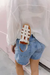 Sandalias de cuero con tiras entrecruzadas, suela plana y hebilla lateral.