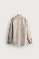 Camisa celeste de lino de corte regular fit, con cuello abotonado, manga larga y cierre frontal de botonadura.