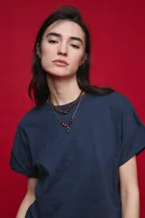 Remera negra de manga corta con cuello redondo y silueta amplia, de hombros caídos y textura suave.