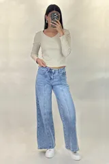 Pantalón de jean estilo wide leg con tiro alto, costuras verticales decorativas en el frente y corte diagonal en la parte inferior de las piernas.