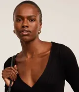 Blusa negra de punto acanalado, con escote en V profundo y mangas largas.