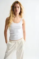 Pantalón de jogging color crudo, de corte amplio, con cintura elástica ajustable con cordón y bolsillos laterales.