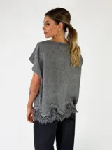 Blusa de lino color beige, con mangas cortas y detalle de encaje en el borde inferior.