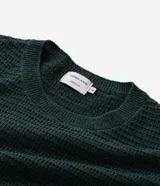 Remera de manga corta y cuello redondo, confeccionada en tejido de tricolina con textura acanalada. Presenta un diseño de corte clásico y ajuste cómodo.