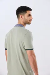 Remera polo de manga corta en color índigo con cuello y botones en contraste. Presenta detalles de color en los puños, aportando un toque sutil y moderno.