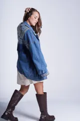 Campera de jean celeste con bordado de flores, tachas y flecos azules.