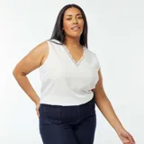 Blusa blanca sin mangas con cuello en V y borde de encaje.