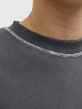 Buzo gris oscuro de manga larga con cuello redondo, calce relajado, costuras visibles en contraste y pequeño estampado con el logo en el pecho.