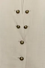 Blazer de cuello redondo con escote en pico, manga larga y cierre frontal con botones metálicos. Presenta falsos bolsillos con solapa en el delantero y un diseño estructurado.