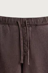 Pantalón jogger relaxed fit de color marrón con efecto lavado, cintura elástica ajustable con cordón y bolsillos laterales.