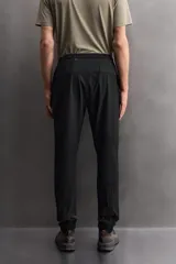Pantalón de jogging negro confeccionado en tejido técnico ligero y elástico, corte slim fit, con cintura elástica ajustable con cordón, bolsillos laterales y trasero con cierre de cremallera, bandas reflectantes en las piernas y bajos ajustables con cremallera.