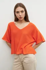 Sweater naranja de tejido de punto, corte oversized y escote en V.