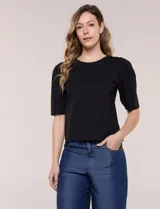 Remera de algodón negro, de silueta semi entallada, con escote redondo y mangas cortas abullonadas al codo con frunces en los hombros.