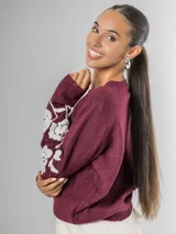 Sweater de tejido de punto color borgoña con escote en V y bordado de flores blancas en las mangas.