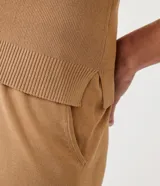 Blusa color beige en tejido de punto acanalado, con cuello polo y cremallera.