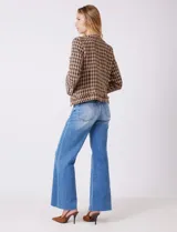 Chaqueta de tweed marca Nanette, color marrón y beige con estampado pata de gallo. Cuello redondo, abertura central, bolsillos delanteros y puños con botones perlados. Terminación desflecada y forro interno.