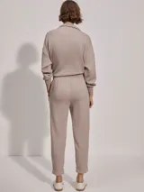 Pantalón de jogging color taupe, confeccionado en tejido DoubleSoft, con corte ajustado, pinzas delanteras y traseras, y puños enrollados en el bajo.