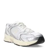 Championes urbanos New Balance modelo 530, color blanco con detalles en plateado. Presentan una estructura de malla transpirable con superposiciones sintéticas, entresuela con tecnología ABZORB para mayor amortiguación y suela de goma resistente.