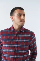 Camisa de viyela a cuadros negros, blancos y rojos, de corte slim fit, con bolsillos en el pecho, manga larga y cierre con botones.