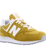 Championes urbanos New Balance modelo 574, color amarillo mostaza con detalles en blanco. Confeccionados en una combinación de gamuza y malla, presentan el logo N característico en los laterales y entresuela con tecnología ENCAP para mayor amortiguación.