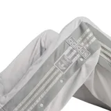 Pantalón deportivo Adidas Adibreak color gris claro, con cintura elástica ajustable, corte recto y bolsillos laterales. Presenta las tres tiras características de la marca en color gris oscuro a lo largo de las piernas.