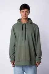 Buzo tipo canguro con capucha, confeccionado en una combinación de algodón rústico y microfibra. Presenta un diseño bicolor en tonos rosado y verde militar, con bolsillo frontal tipo canguro en contraste, cordones ajustables y estampa personalizada en el frente.