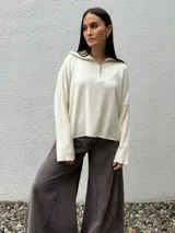 Sweater de tejido bremer color marrón, con cuello polo y cierre frontal parcial, de manga larga y diseño holgado.
