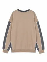 Buzo de cuello redondo en color beige con detalles en gris oscuro en el cuello, puños y paneles laterales. Presenta un pequeño logo estampado en el pecho y líneas blancas decorativas en las mangas.
